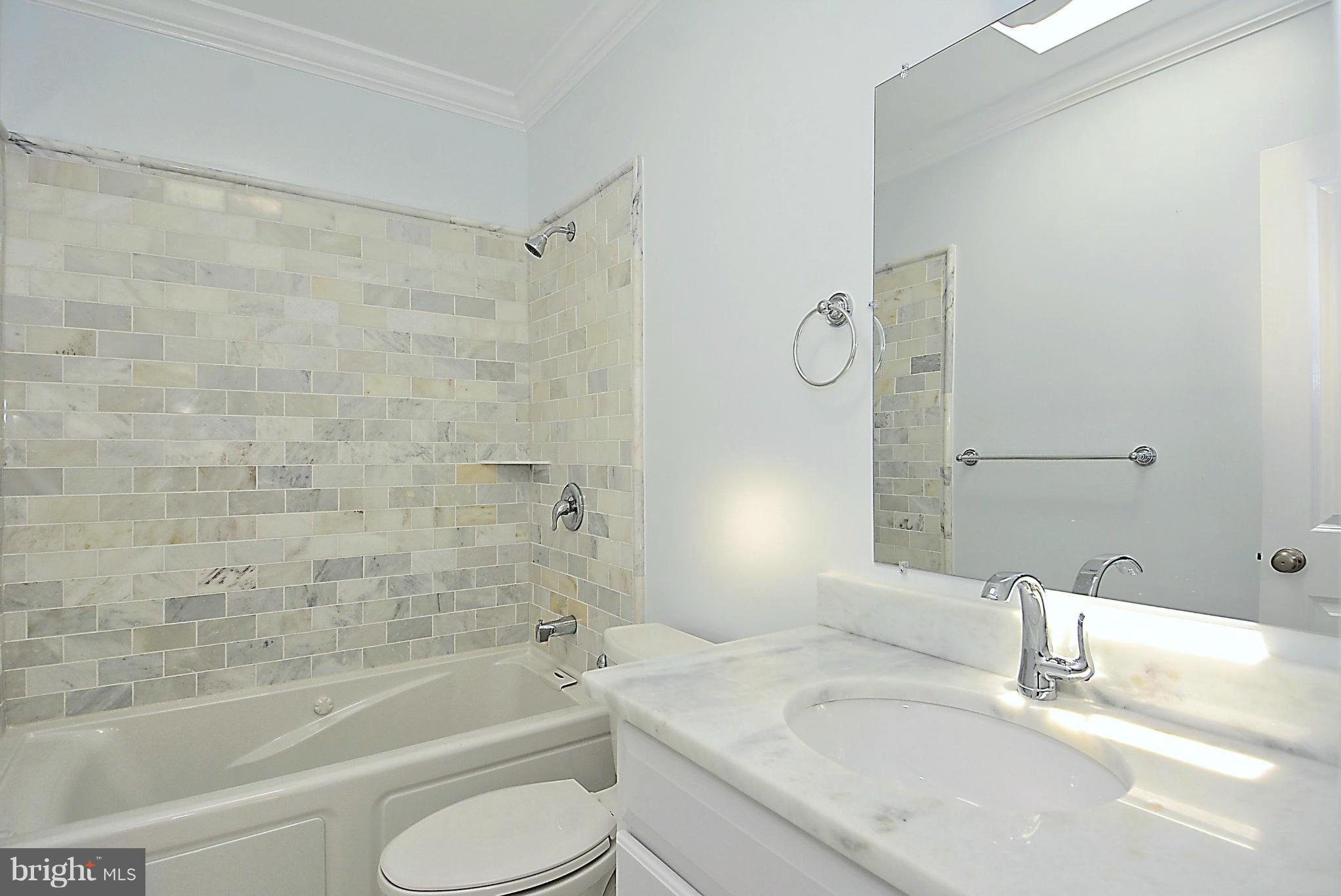 1102 4th Street Northeast Washington, DC 20002 - Photo 10 of 17 a bathroom with a granite countertop bathtub shower sink vanity mirror and toilet