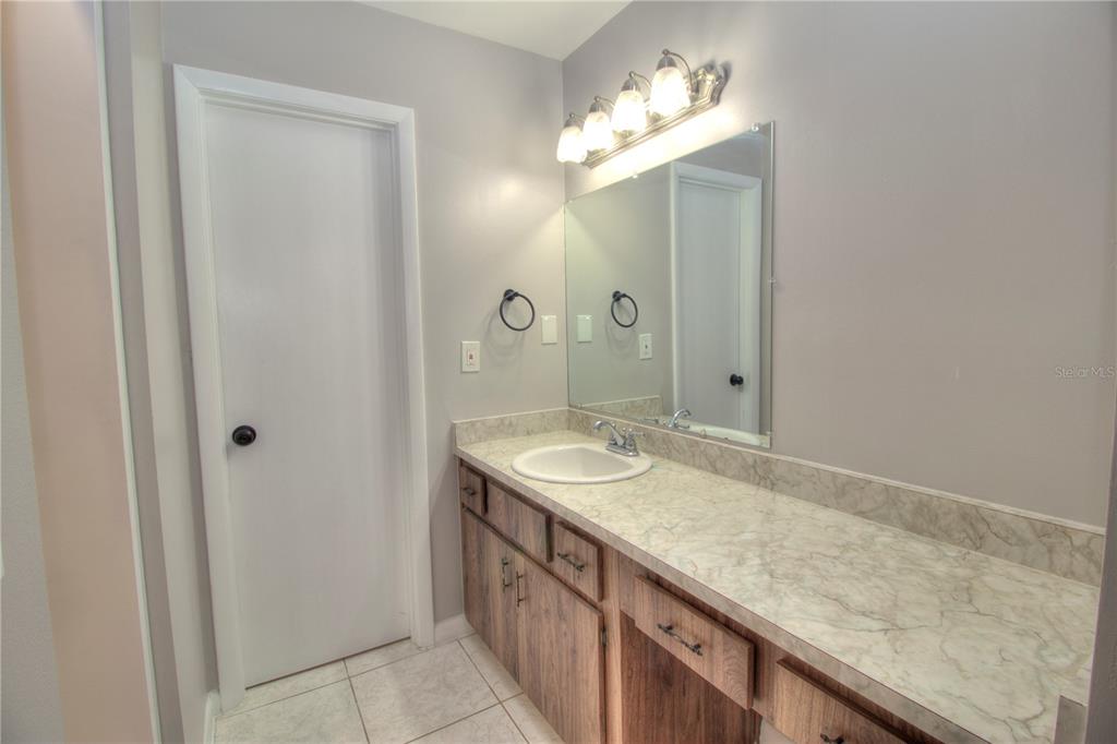 10182 Southwest 87th Terrace Ocala, FL 34481 - Photo 11 of 26 a bathroom with a granite countertop sink and a mirror