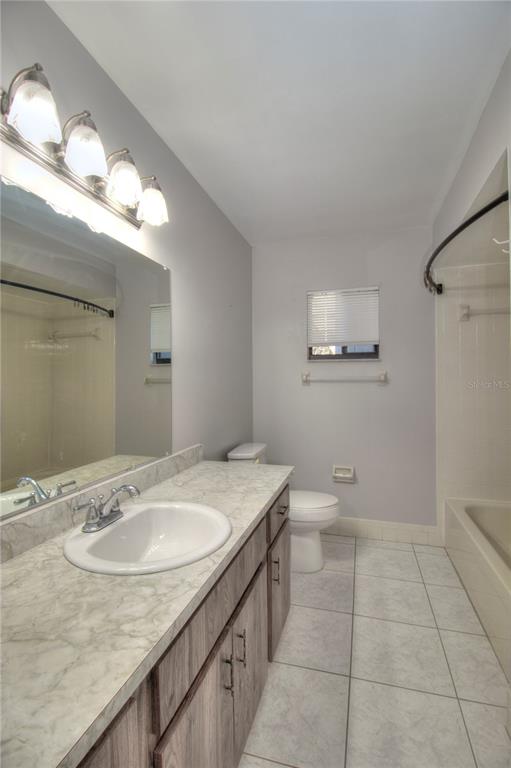 10182 Southwest 87th Terrace Ocala, FL 34481 - Photo 16 of 26 a bathroom with a granite countertop sink a toilet and mirror