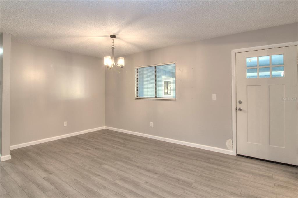 10182 Southwest 87th Terrace Ocala, FL 34481 - Photo 2 of 26 a view of an empty room with wooden floor and a window