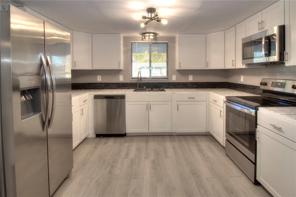 10182 Southwest 87th Terrace Ocala, FL 34481 - Photo 4 of 26 a kitchen with stainless steel appliances granite countertop a stove a sink and a refrigerator