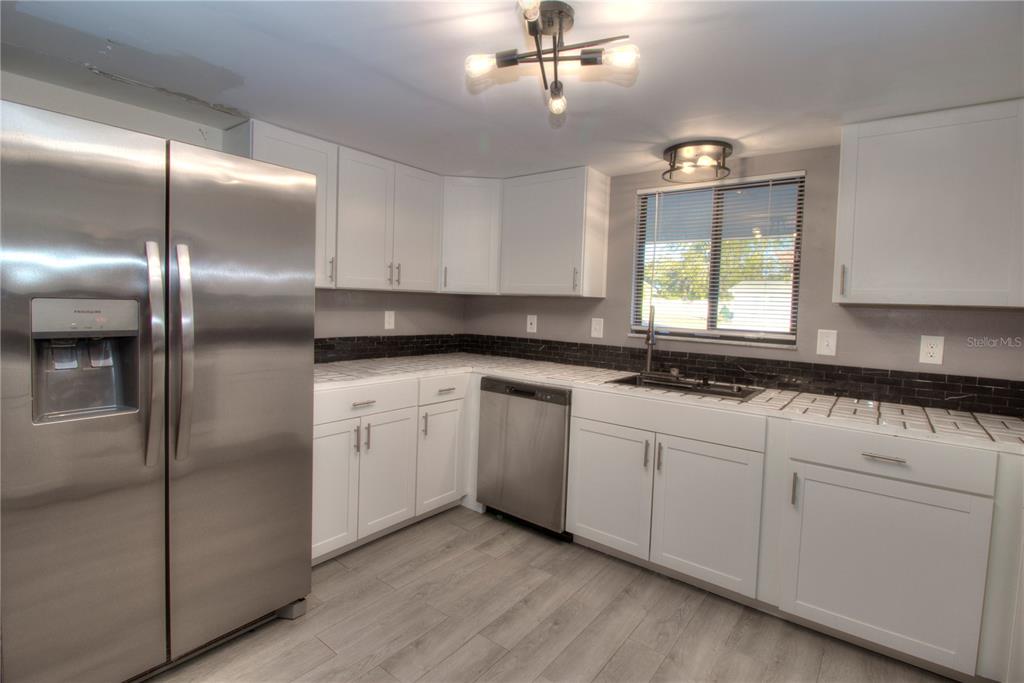 10182 Southwest 87th Terrace Ocala, FL 34481 - Photo 5 of 26 a kitchen with granite countertop stainless steel appliances cabinets a sink and a window
