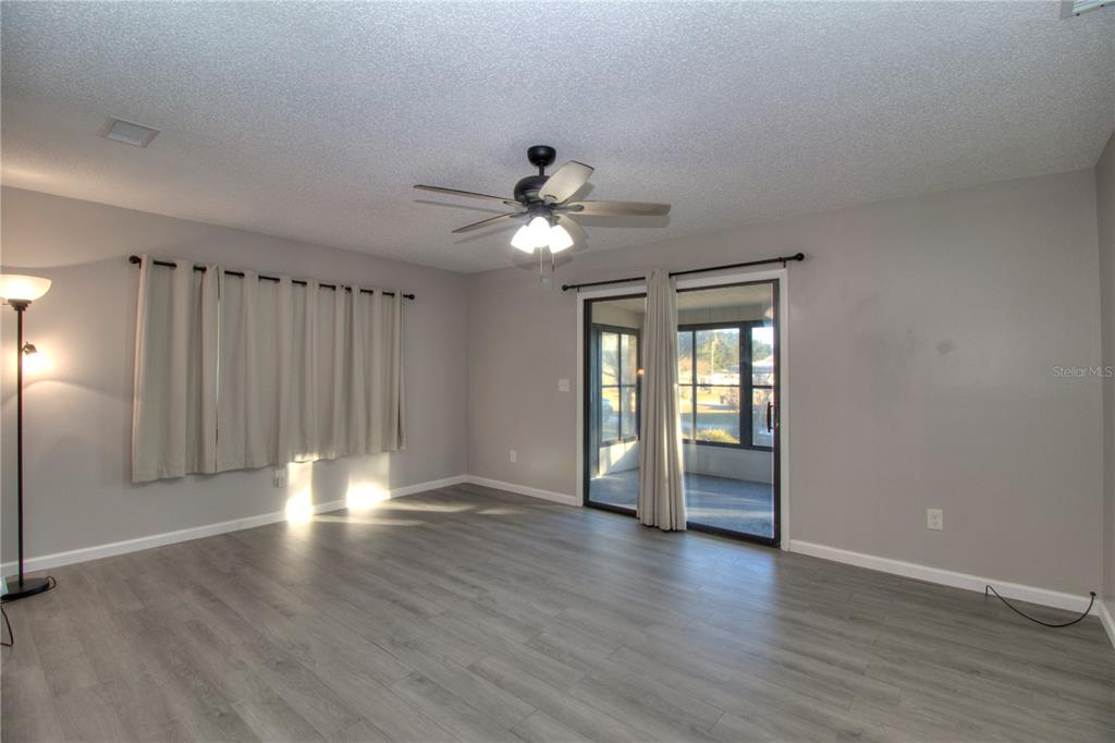 10182 Southwest 87th Terrace Ocala, FL 34481 - Photo 7 of 26 a view of an empty room with a window and wooden floor