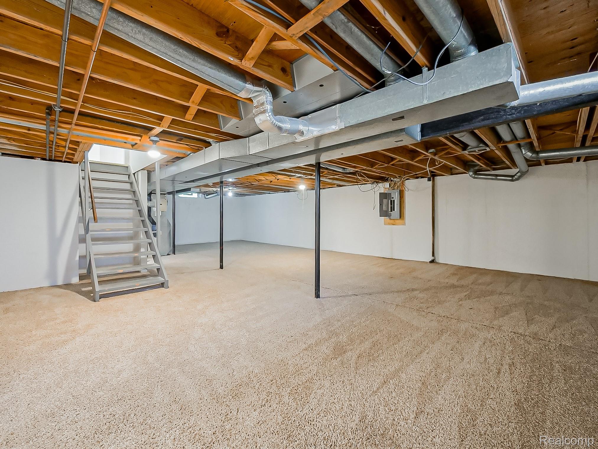 42195 Park Ridge Road Novi, MI 48375 - Photo 40 of 52 Carpeted floor, white painted walls, wood ceiling joists, exposed ductwork, and an electrical panel