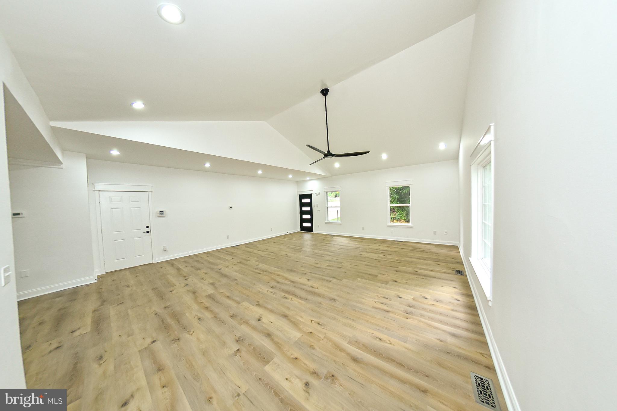3704 Suitland Road Southeast Washington, DC 20020 - Photo 26 of 70 a big room with wooden floor ceiling fan and kitchen view