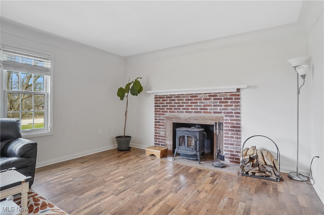 33825 Cannon Road Solon, OH 44139 - Photo 27 of 44 Living room featuring wood finished floors, baseboards, and a wood stove