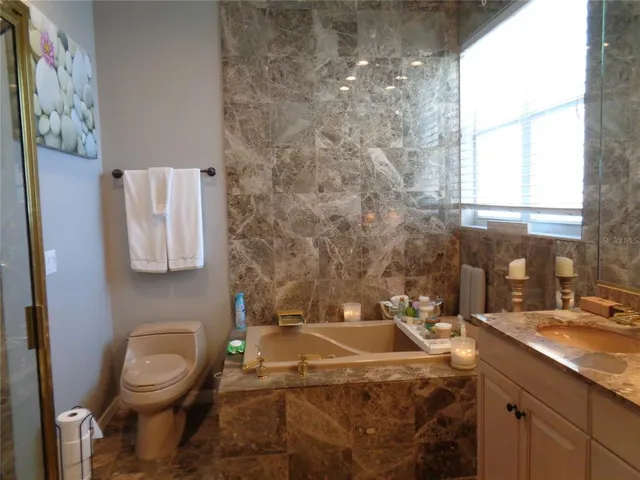 a bathroom with a granite countertop sink a toilet and a mirror