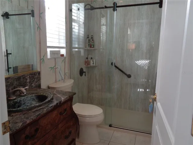 a bathroom with a granite countertop shower a toilet and a sink
