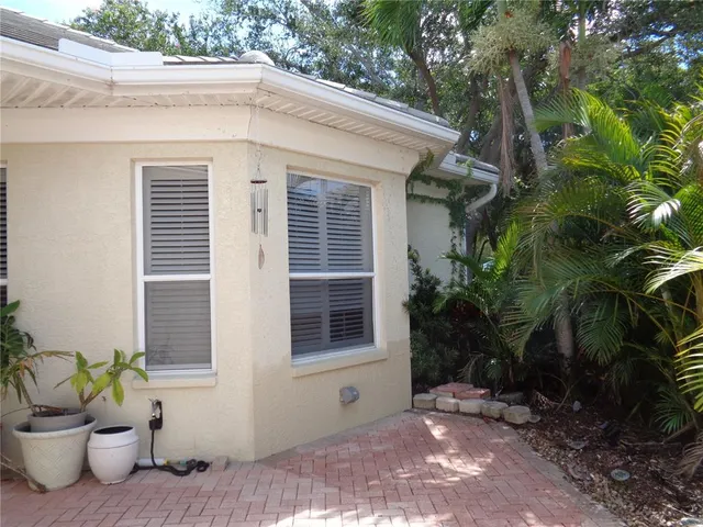 a view of a house with a yard and potted plants