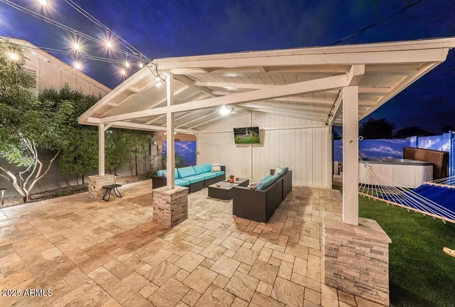 a view of a patio with table and chairs under an umbrella