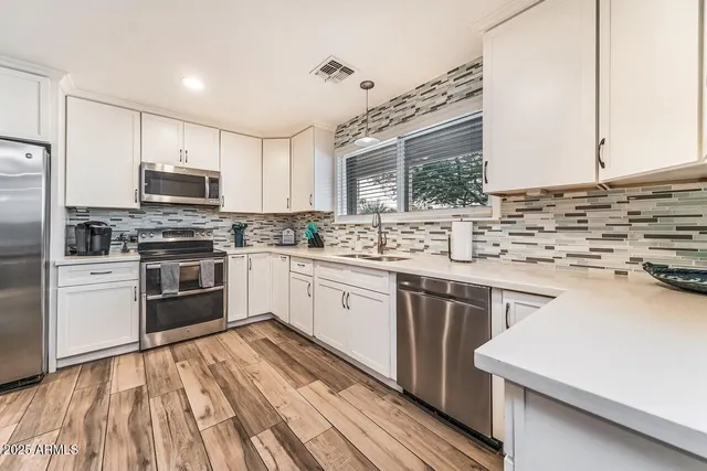 a kitchen with stainless steel appliances a stove sink microwave and cabinets