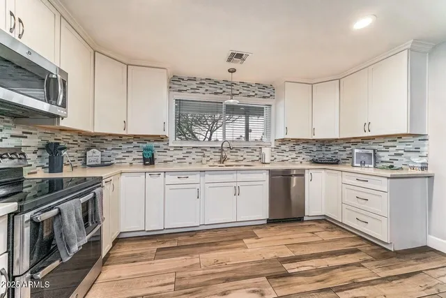 a kitchen with stainless steel appliances granite countertop a stove a sink and a granite counter tops