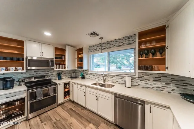 a kitchen with stainless steel appliances a stove sink microwave and cabinets