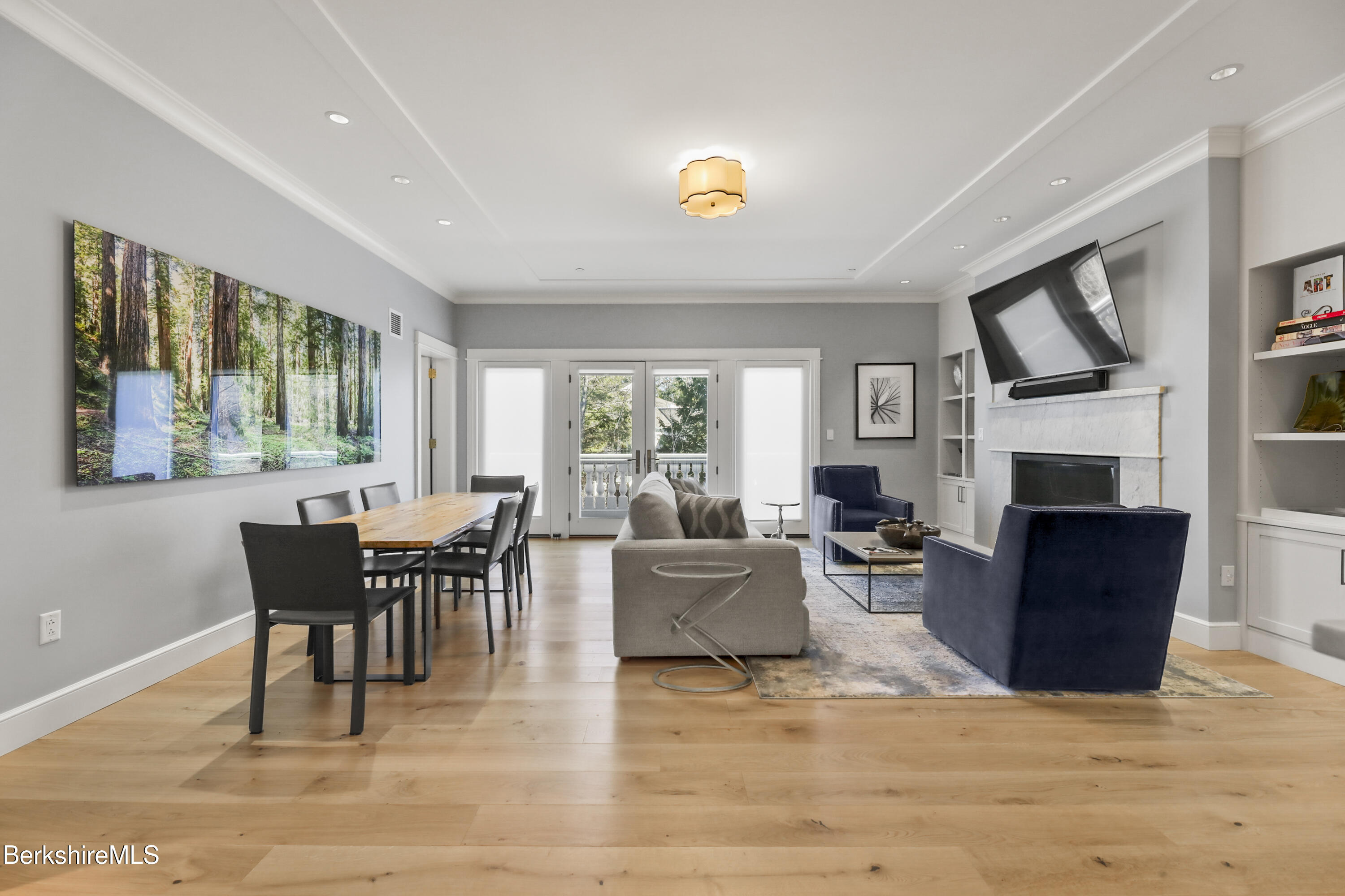 165 Kemble Street, Unit 10 Lenox, MA 01240 - Photo 3 of 24 a living room with furniture a fireplace and a dining table with wooden floor