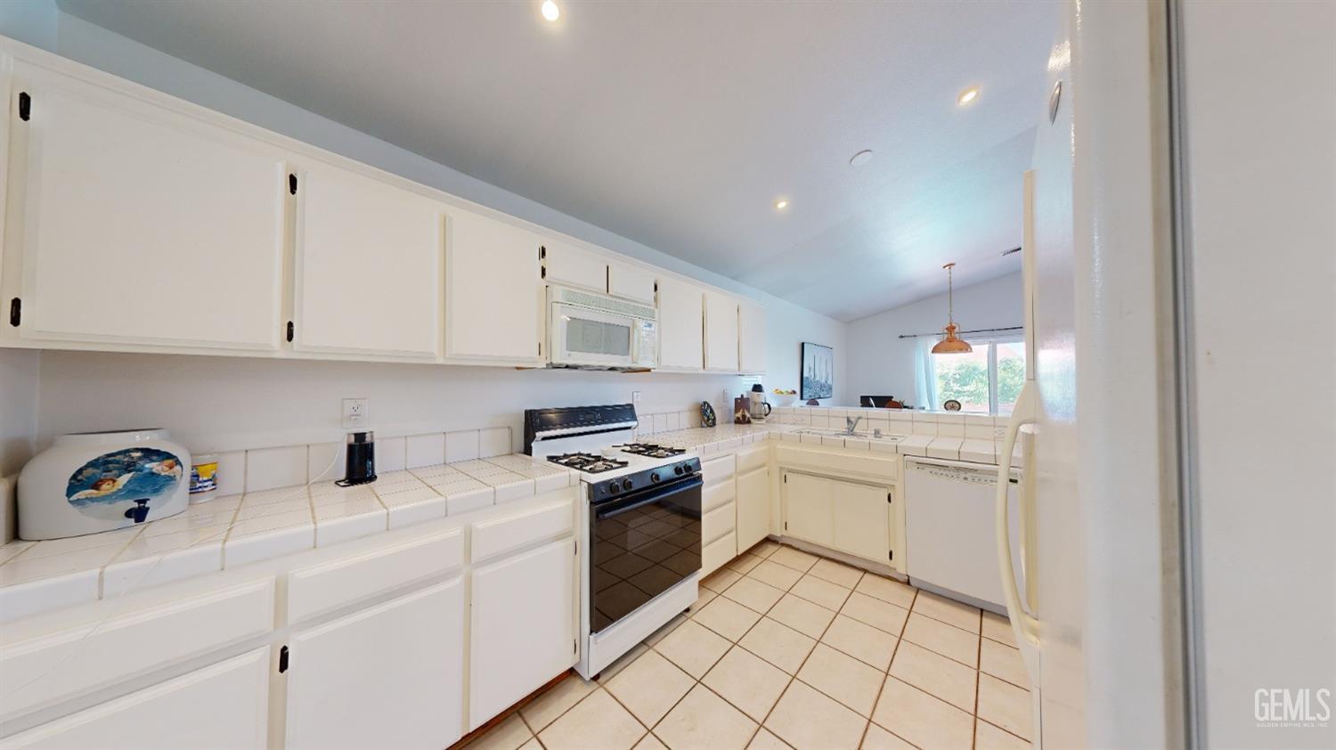 Undisclosed Address Bakersfield, CA 93313 - Photo 9 of 37 a kitchen with white cabinets and white appliances