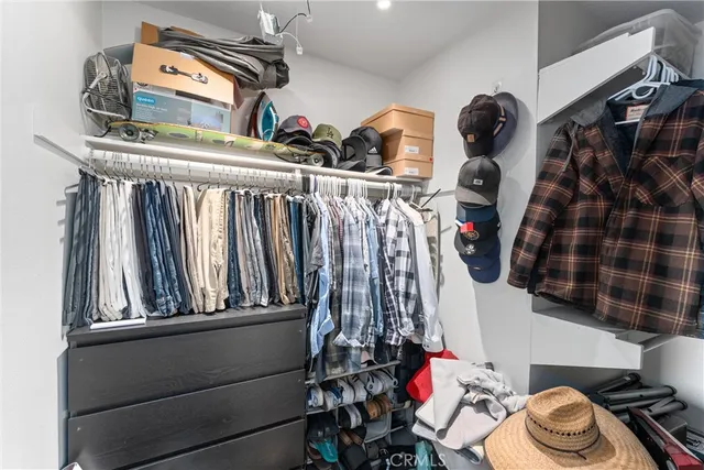 a view of walk in closet with clothes and shoes