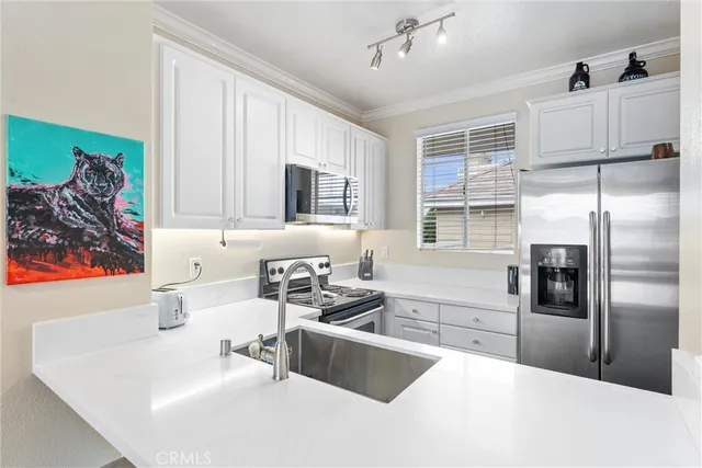a kitchen with stainless steel appliances a refrigerator sink and microwave