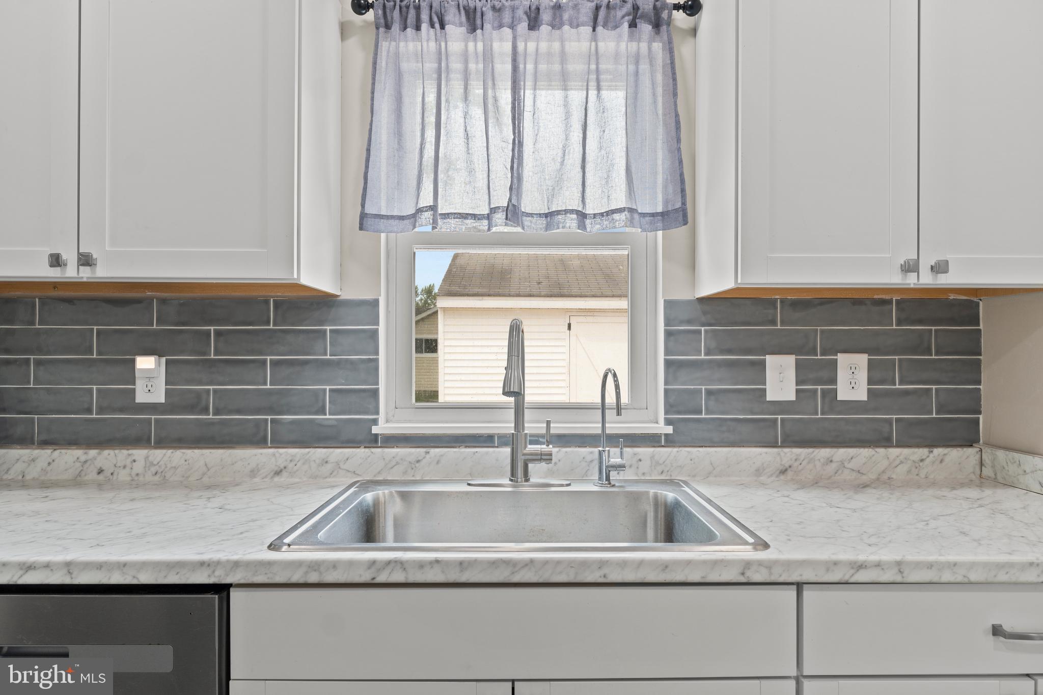 6475 Big Stone Beach Road Milford, DE 19963 - Photo 8 of 52 a kitchen sink with a granite countertop white cabinets and a sink