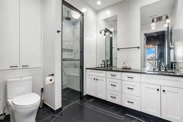 a bathroom with a granite countertop toilet sink and mirror