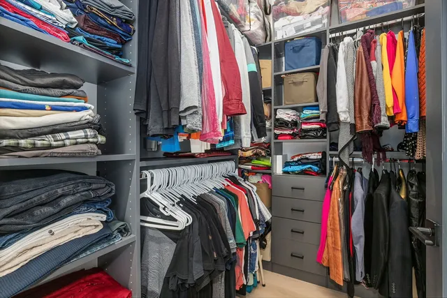 a view of walk in closet with clothes and shoes