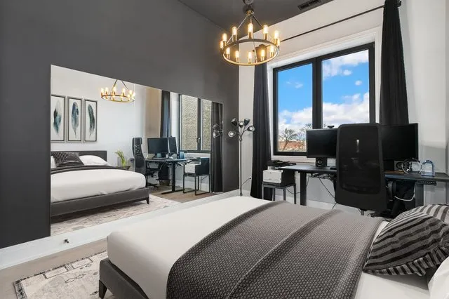 a bedroom with a bed and a chandelier