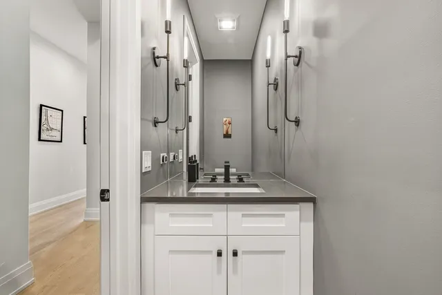a bathroom with a granite countertop sink a mirror and shower
