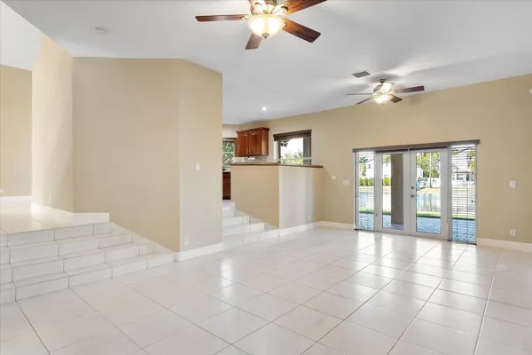 a view of a livingroom with a ceiling fan a kitchen space a ceiling fan and windows
