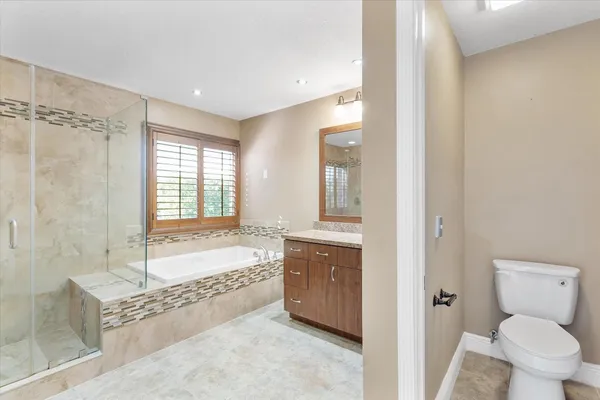 a spacious bathroom with a tub sink and mirror