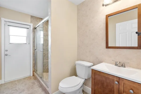 a bathroom with a sink a toilet and shower