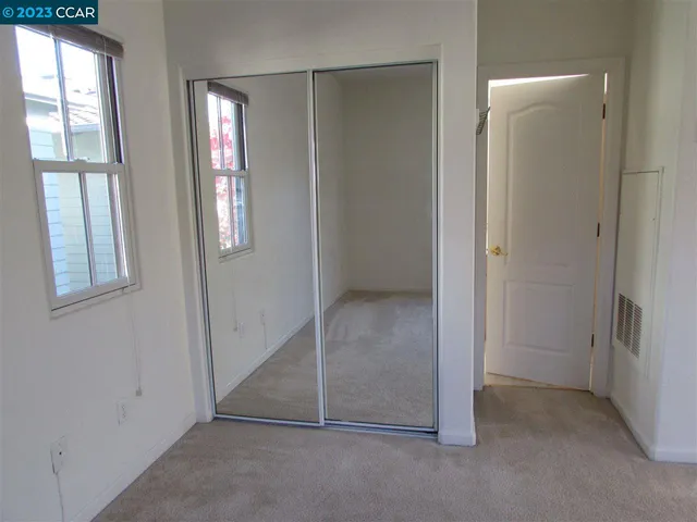 an empty room with windows and closet