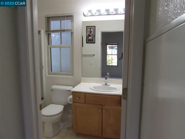 a bathroom with a toilet sink vanity and mirror
