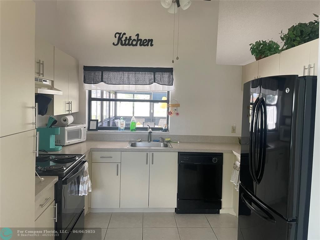 5675 Northpointe Lane Boynton Beach, FL 33437 - Photo 4 of 8 a kitchen with a sink stove and refrigerator