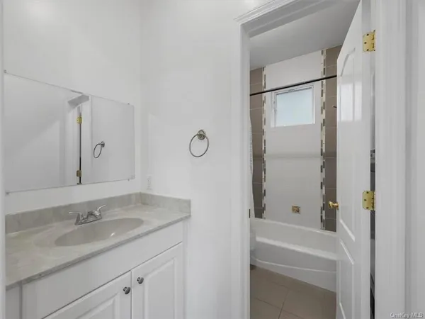 a bathroom with a granite countertop sink mirror toilet and bathtub