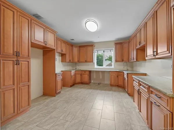 a large kitchen with stainless steel appliances granite countertop a refrigerator and a sink