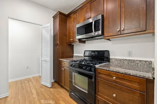 a kitchen with stainless steel appliances granite countertop a stove and a microwave