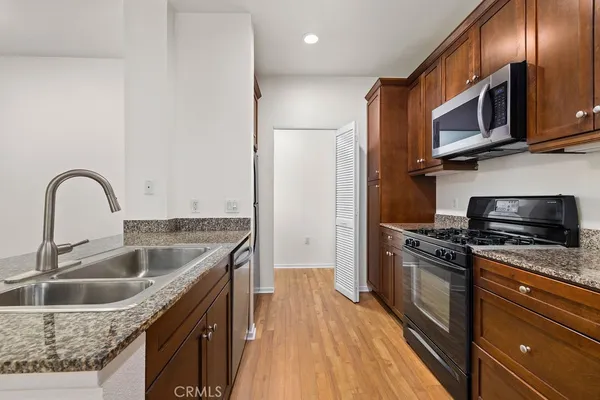 a kitchen with stainless steel appliances granite countertop a sink a stove and a refrigerator