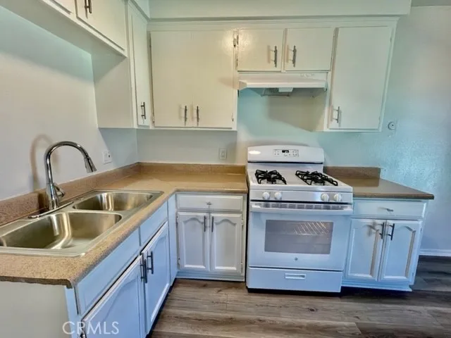 a kitchen with sink a stove and cabinets