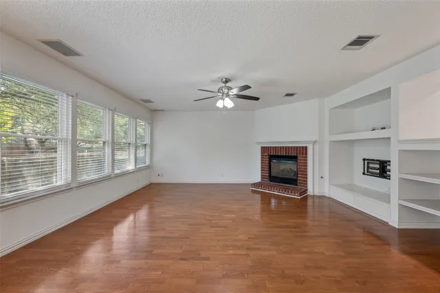 a view of a livingroom with a ceiling fan window and wooden floor