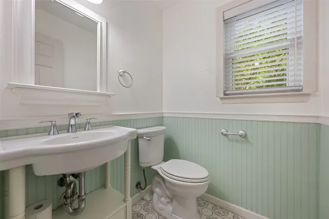 a bathroom with a sink a toilet and a mirror