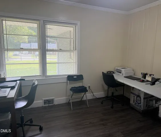 a view of a workspace with furniture and a window
