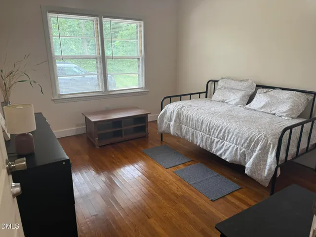 a bedroom with a bed and wooden floor