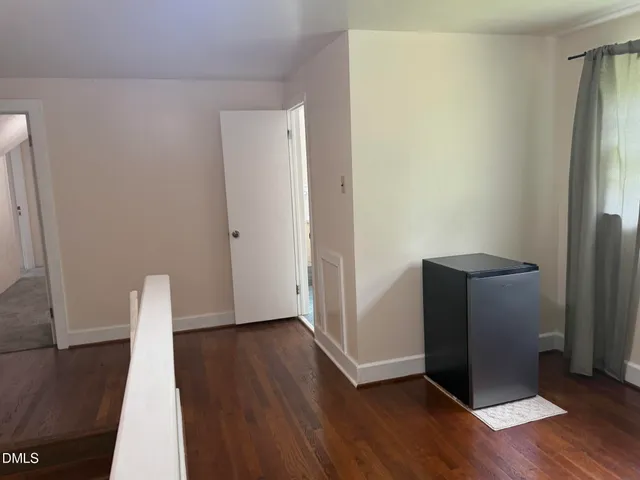 an empty room with wooden floor and a window