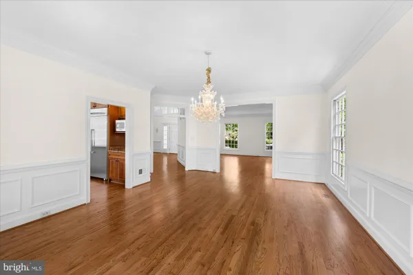 a view of a room with wooden floor staircase and a kitchen