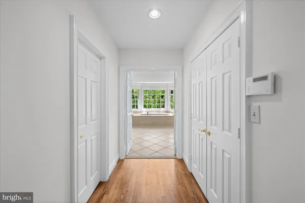 a view of a hallway with wooden floor and a window