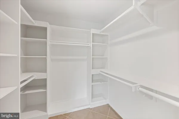 a view of walk in closet with empty racks