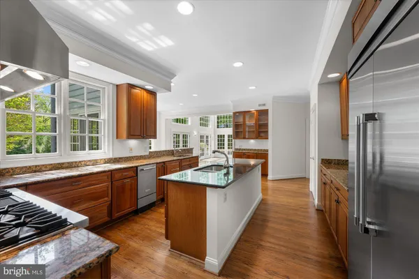 a large kitchen with stainless steel appliances granite countertop a large counter top a stove and a refrigerator