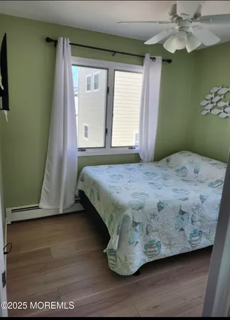 a bedroom with a bed and a flat tv screen on dresser