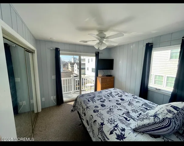 a bedroom with a bed flat screen tv and a large window