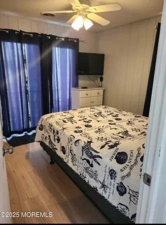 a bedroom with a bed and a flat tv screen on dresser