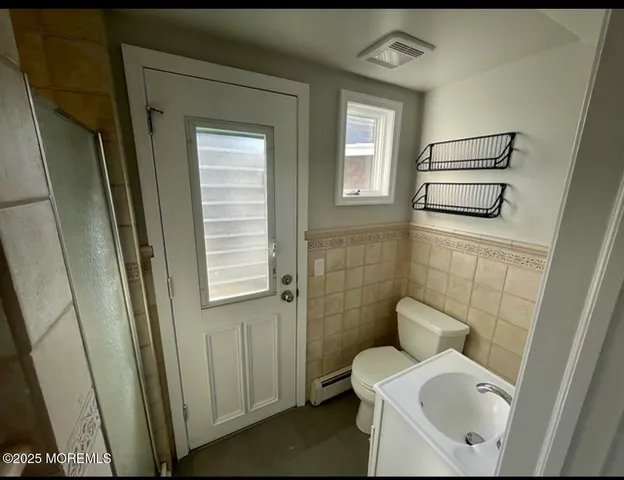 a bathroom with a sink a toilet and a mirror